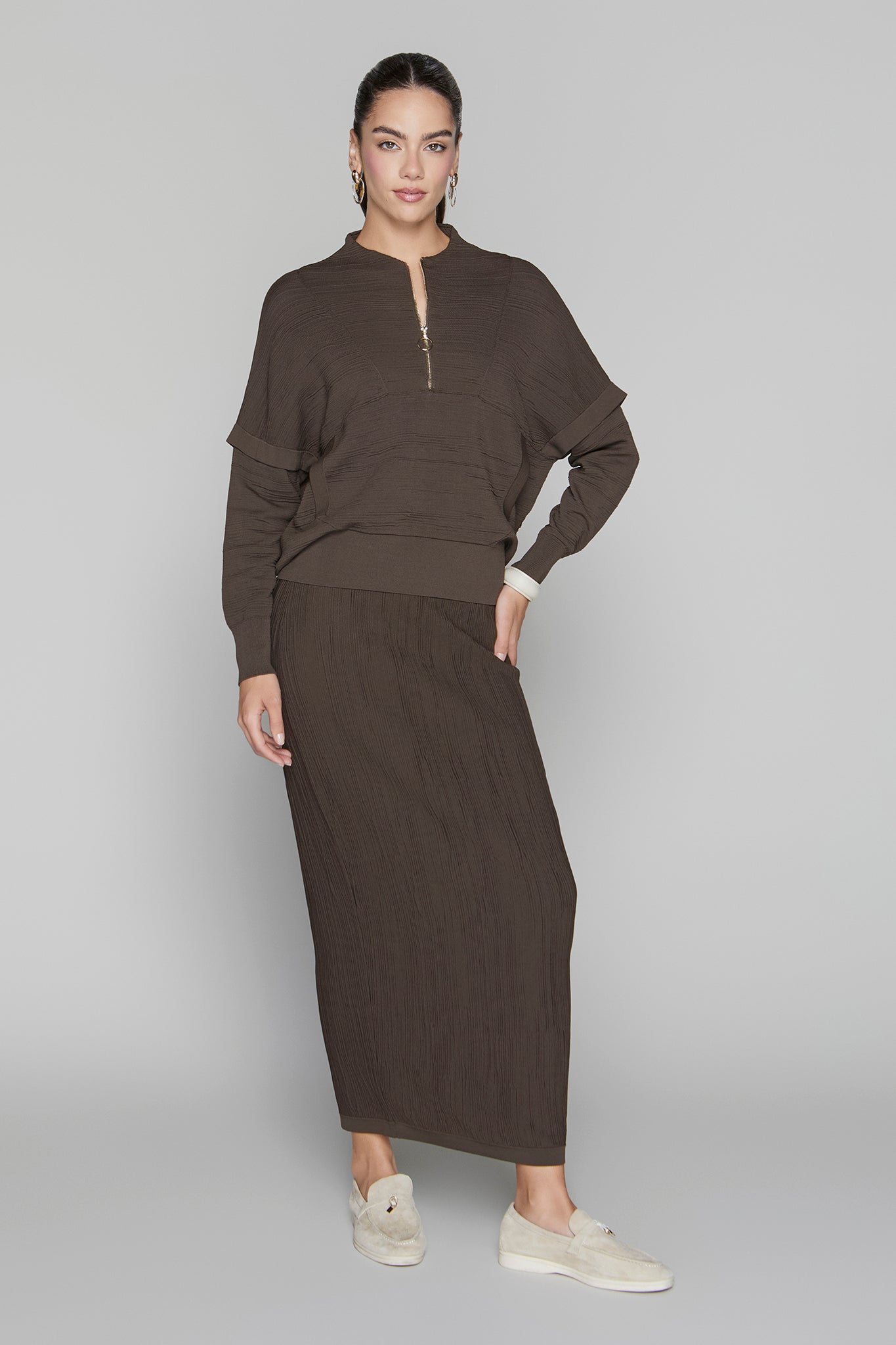 Woman wearing a brown outfit on a gray background