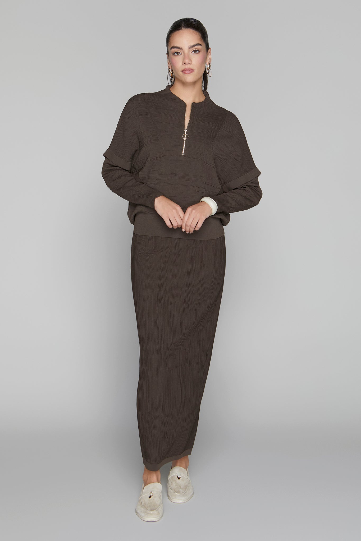 Woman wearing a brown outfit on a gray background