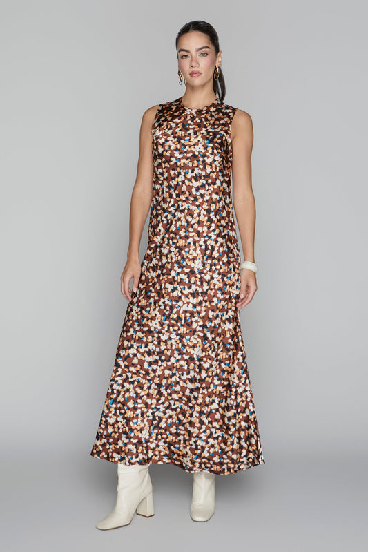 Woman wearing a sleeveless dress with a pattern on a gray background