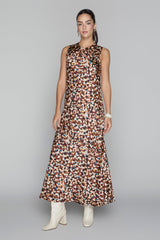 Woman wearing a sleeveless dress with a pattern on a gray background