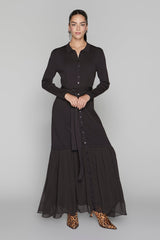 Woman wearing a black dress with buttons on a gray background