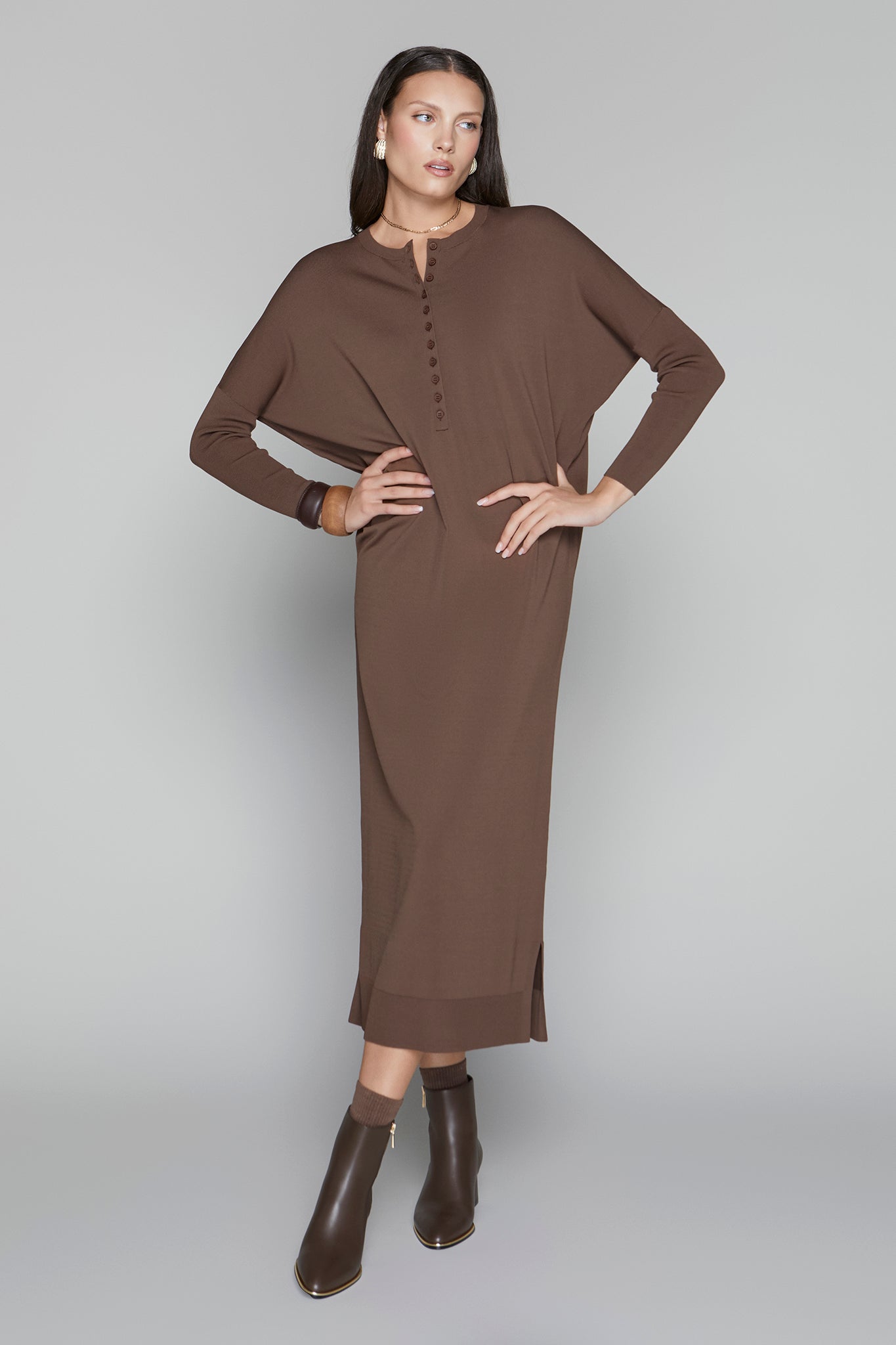 Woman wearing a brown dress against a gray background