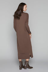 Woman wearing a long brown dress on a gray background
