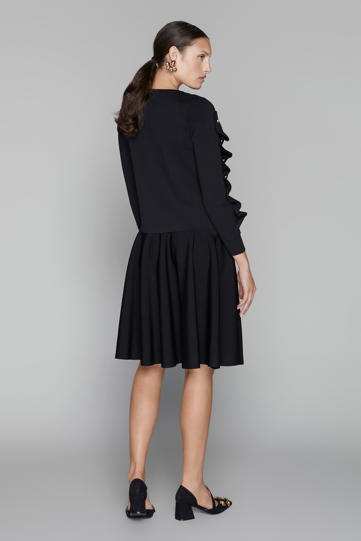 Woman wearing a black dress with a gray background