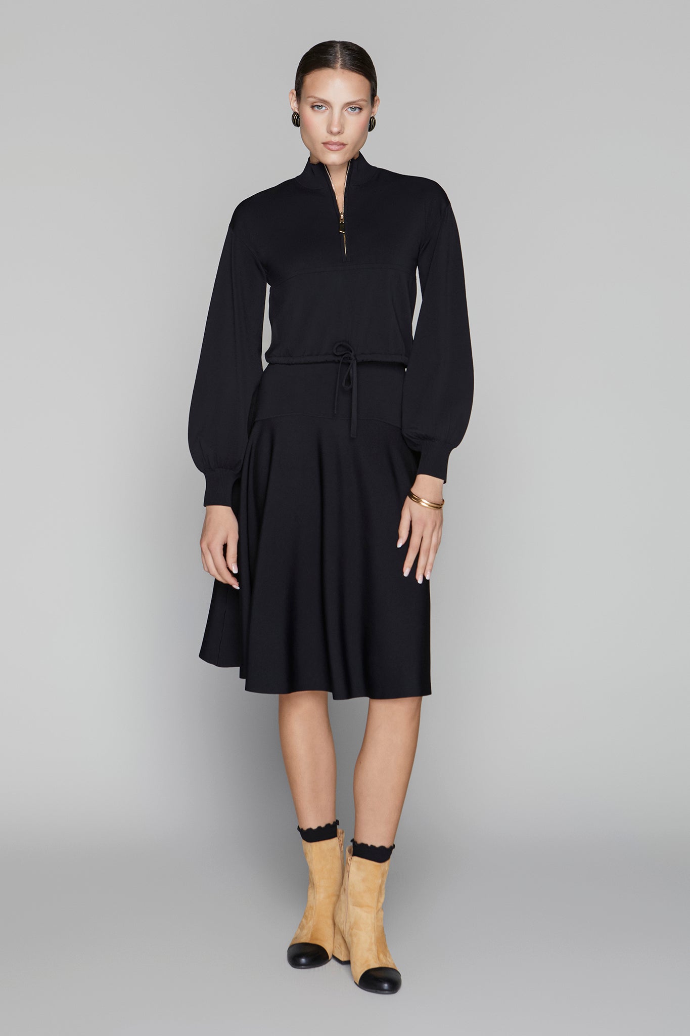 Woman wearing a black dress with a plain background