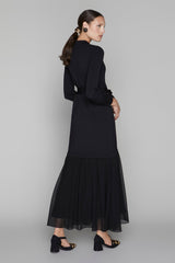 Woman wearing a black dress with a plain background