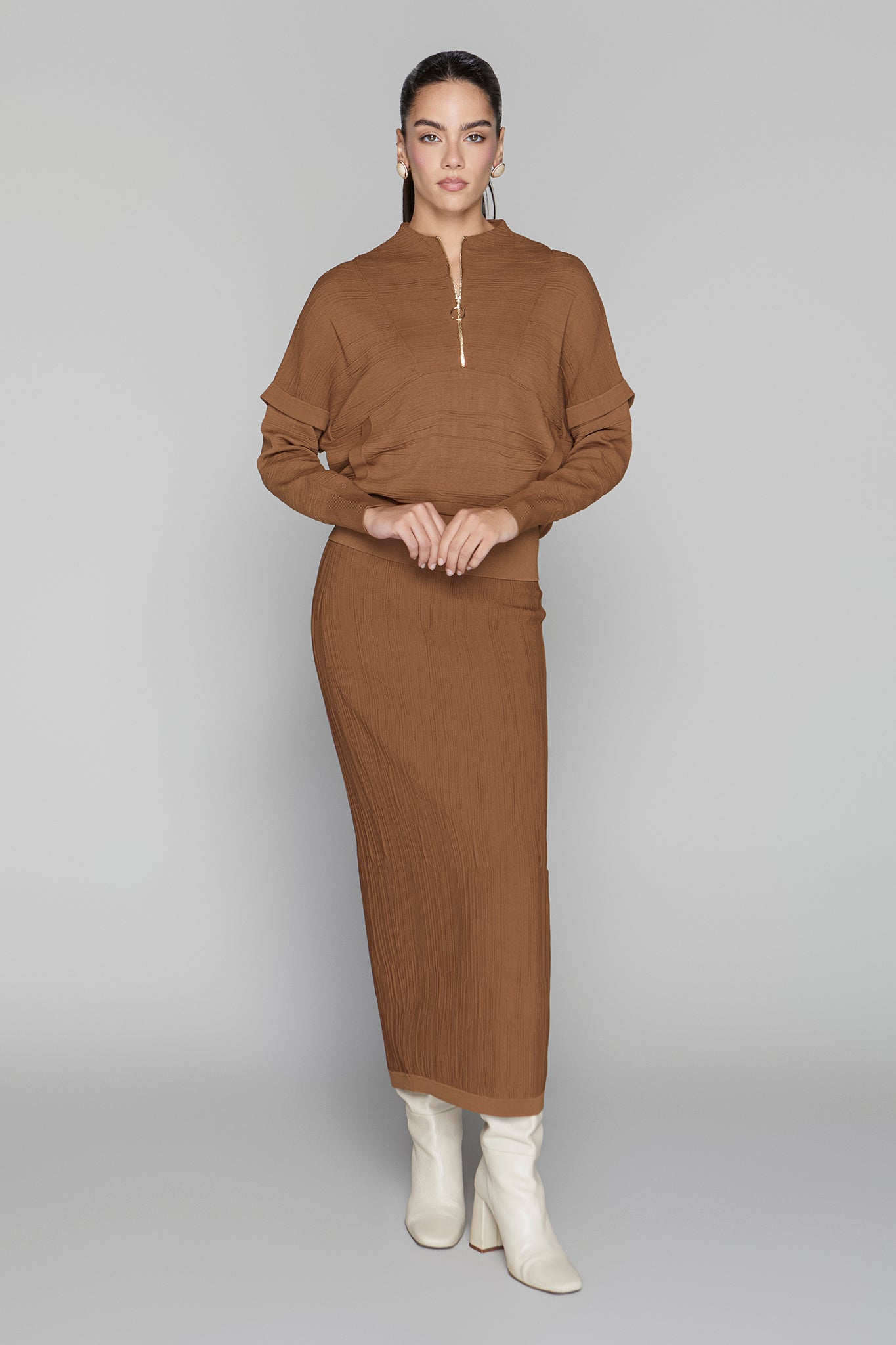 Woman wearing a brown outfit with a plain background