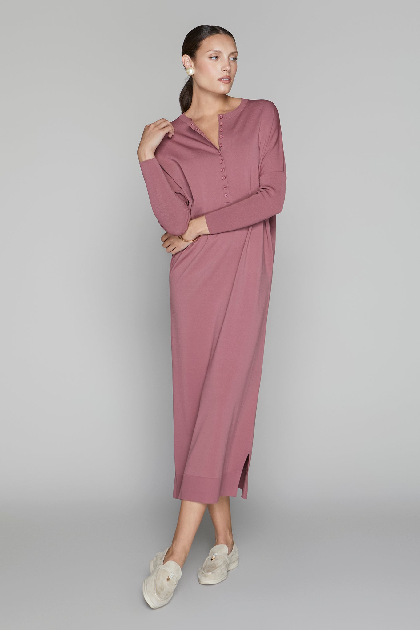 Woman wearing a mauve dress on a gray background