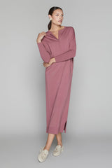 Woman wearing a mauve dress on a gray background