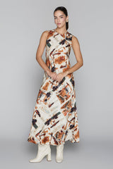 Woman wearing a patterned dress with white boots on a gray background