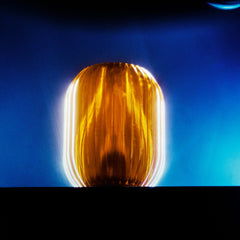 Amber-colored cylindrical object against a blue background