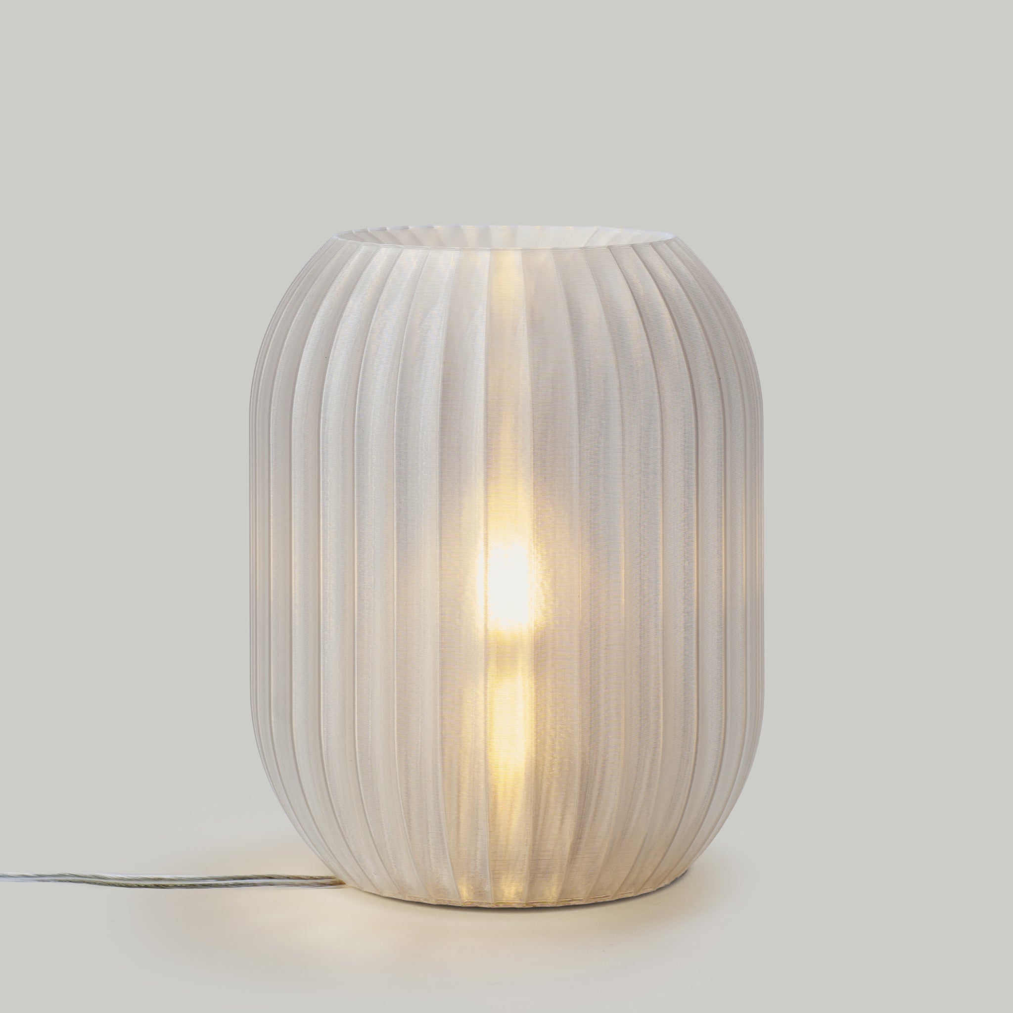 Decorative table lamp with ribbed design on a plain background