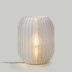 Decorative table lamp with ribbed design on a plain background