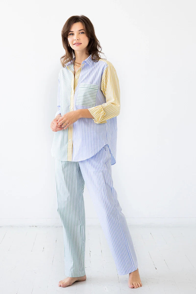 Woman wearing a light blue and white striped pajama set on a white background