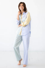 Woman wearing a light blue and white striped pajama set on a white background