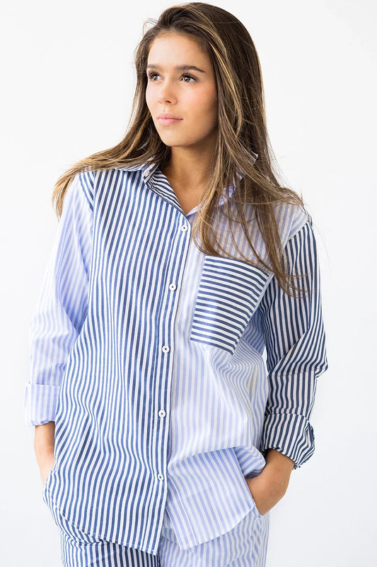 Woman wearing a blue and white striped shirt against a white background