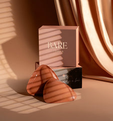 BARE Reva jewelry box with two heart-shaped earrings on a warm-toned background