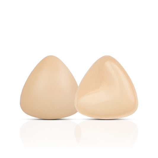Two beige silicone breast forms on a white background