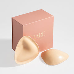 Two beige silicone padds with a 'BARE' branded box on a light gray background