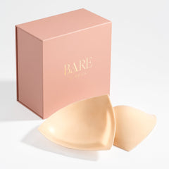 Bare brand packaging with two beige silicone paddings on a white background