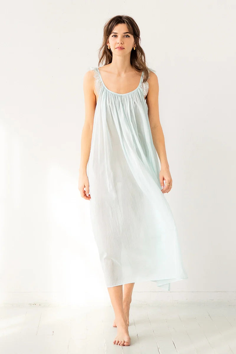 Woman wearing a light blue slip dress on a white background