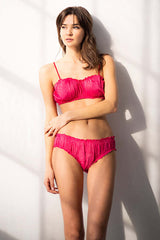 Woman wearing a pink bikini against a white background