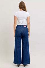 Person wearing blue jeans and a white t-shirt on a plain background