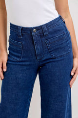 Blue jeans worn by a person on a plain background