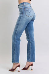 Blue jeans worn by a person on a plain background
