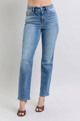 Blue jeans worn by a person on a plain background