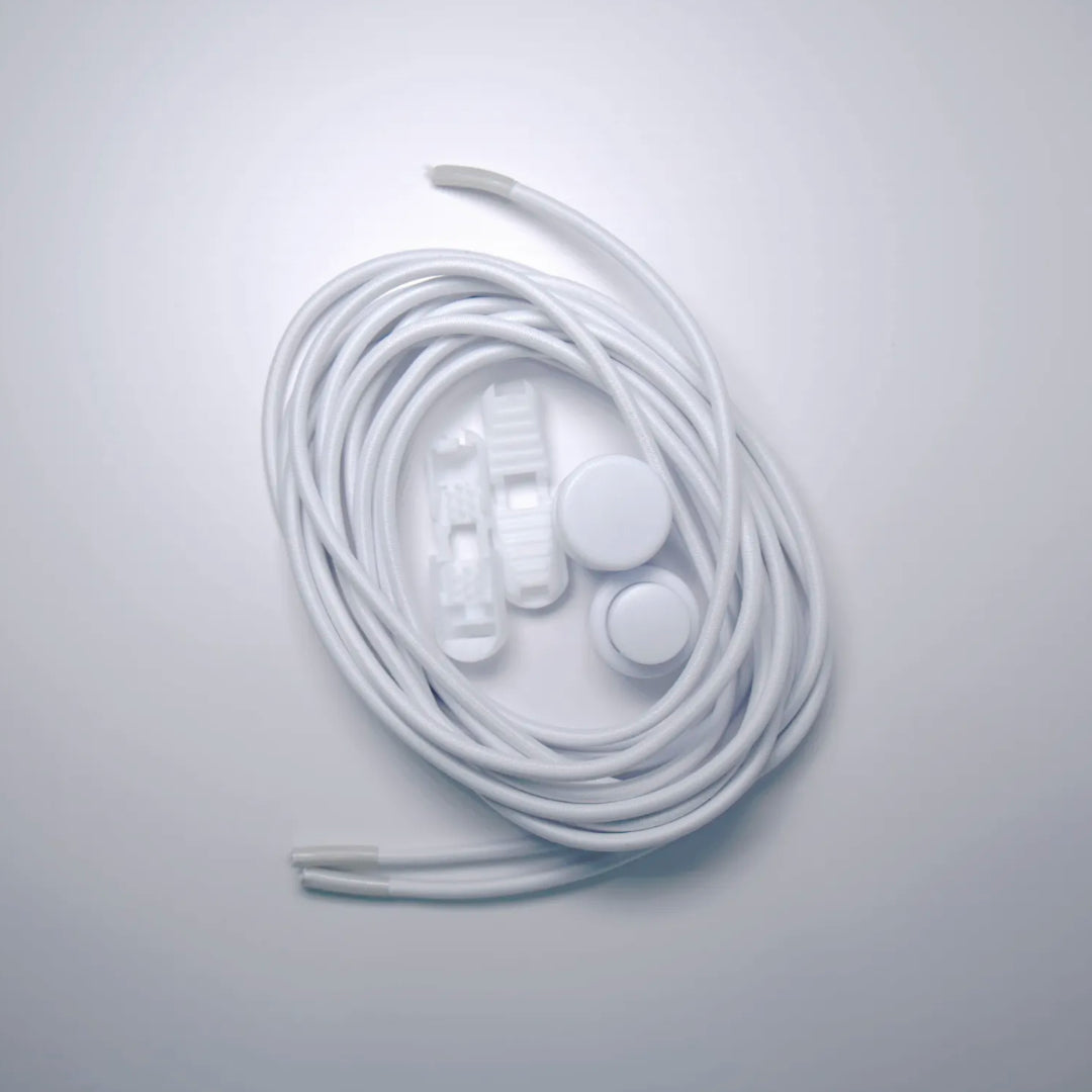White earbuds and charging cable coiled on a light gray background