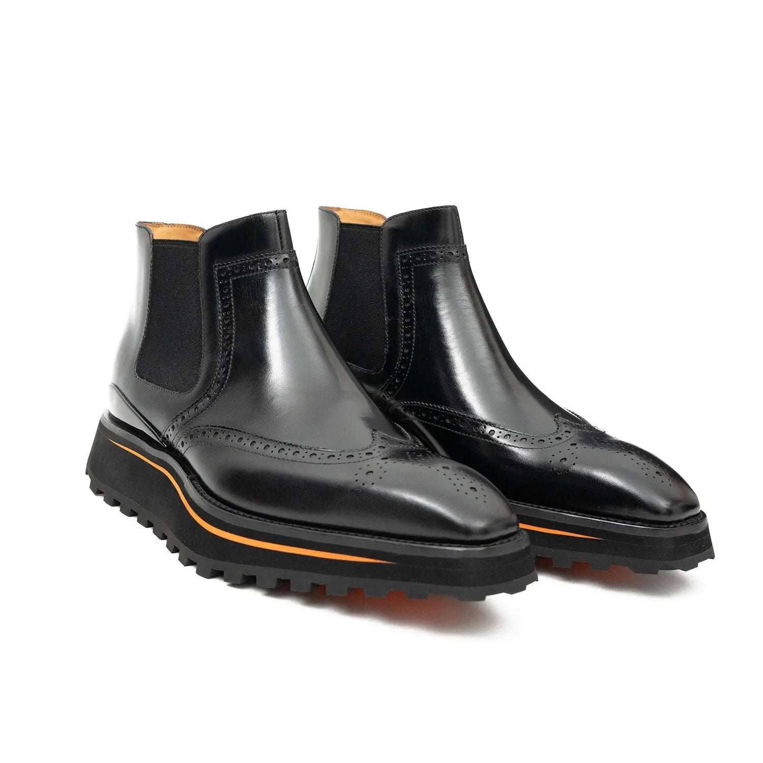 Black leather boots with orange sole on a white background