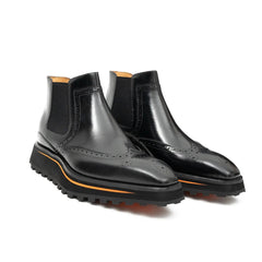 Black leather boots with orange sole on a white background