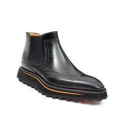 Black leather Chelsea boot with orange sole on a white background