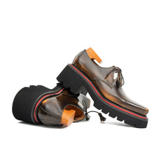 Brown leather shoes with black soles on a white background