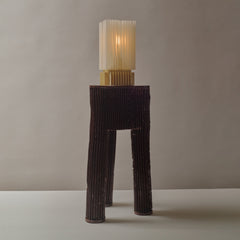 Tall, ribbed lamp with a textured base and cylindrical shade on a neutral background