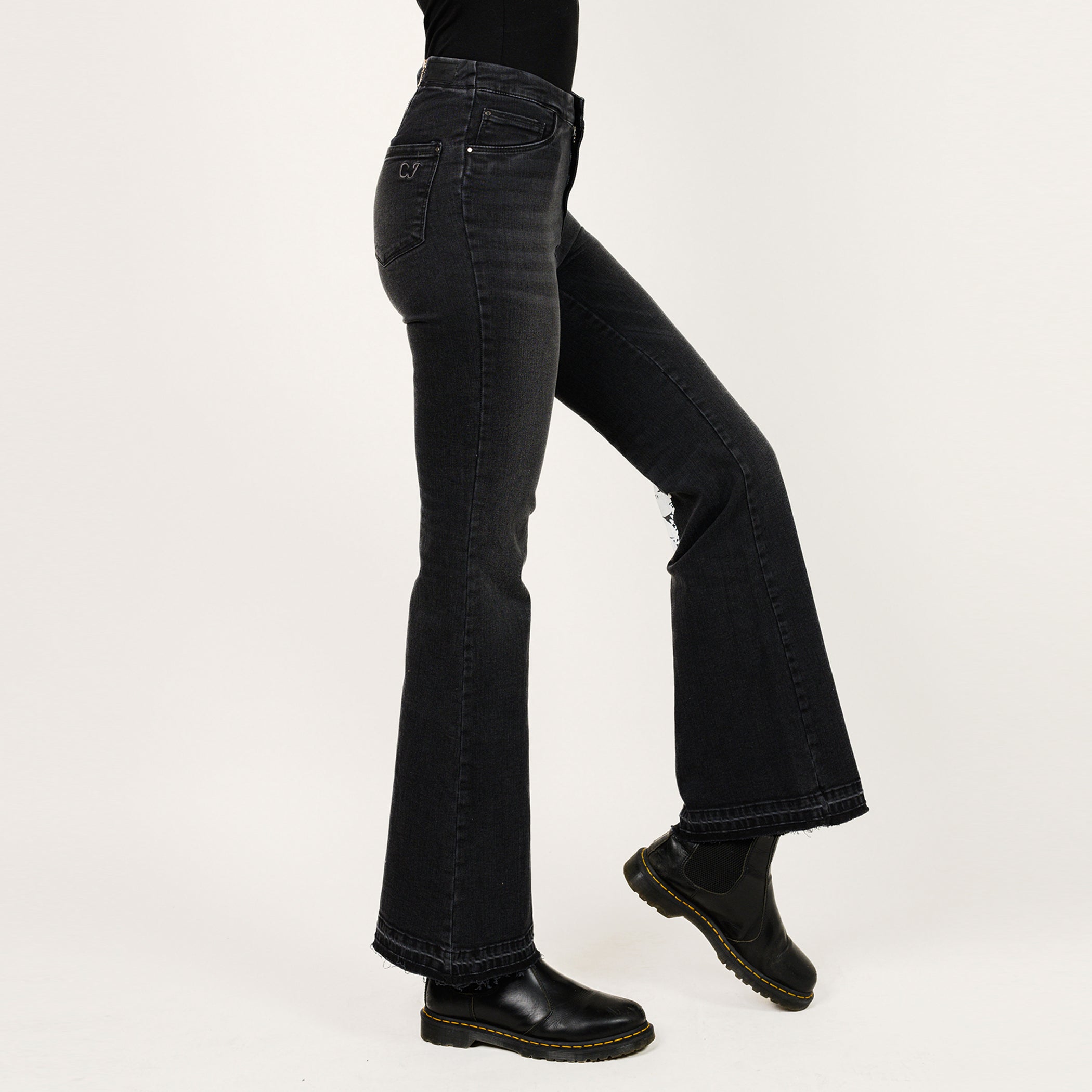 Black flared jeans worn by a person on a white background