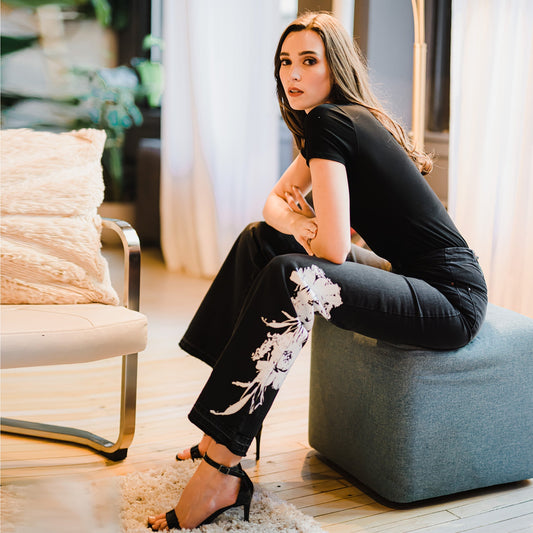 Woman sitting on a blue ottoman in a stylish living room.