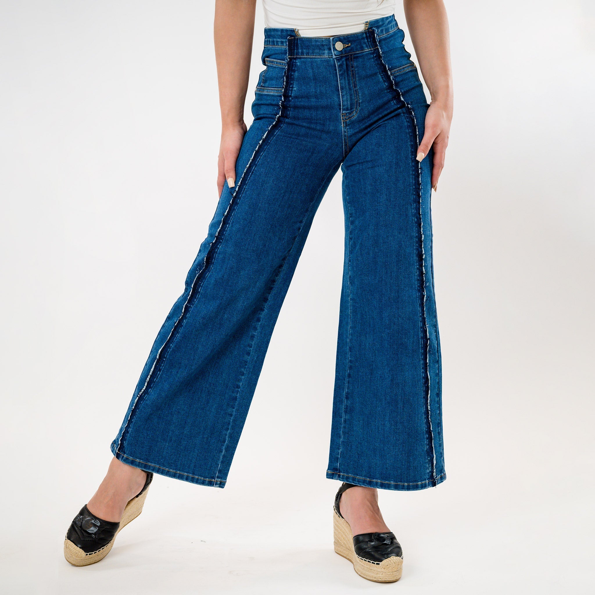 Blue wide-leg jeans worn by a person on a white background