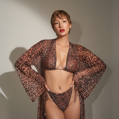 Person wearing a leopard print bikini and cover-up against a neutral background
