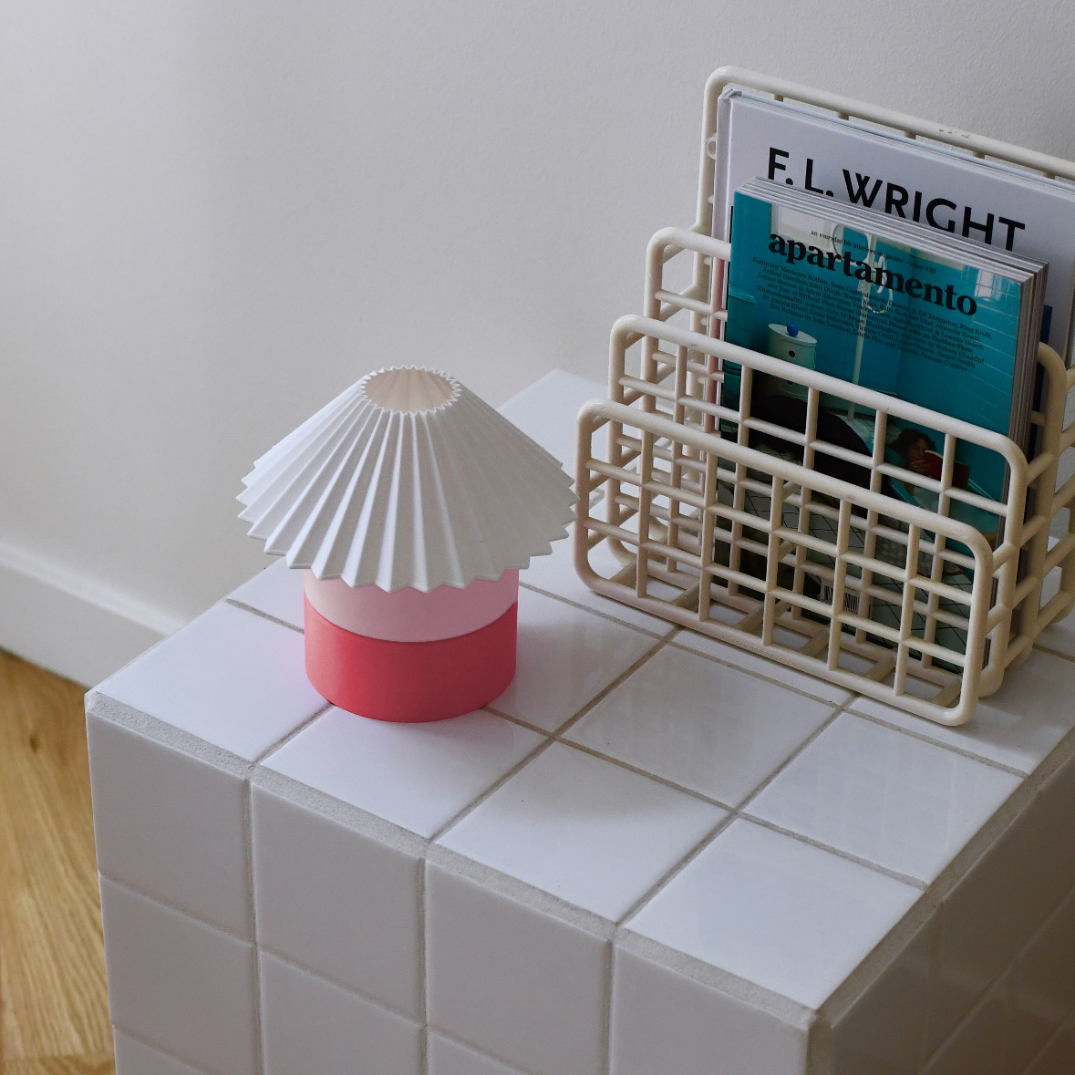 Small decorative item on a tiled surface next to a book titled 'F.L. Wright apartamento'.