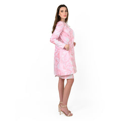 Woman wearing a pink dress with white patterns on a white background