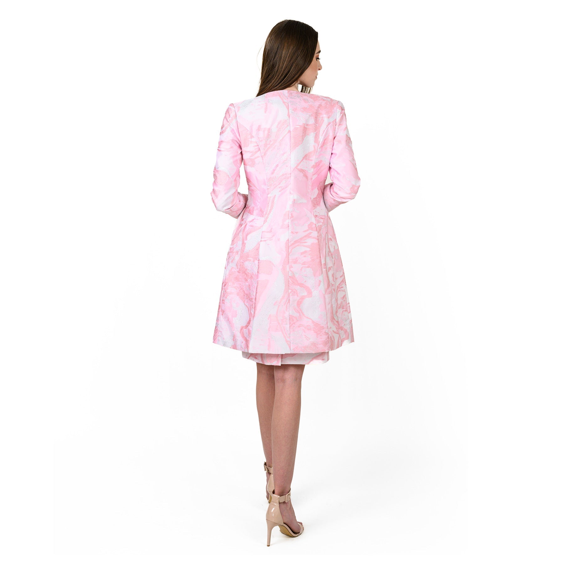 Woman wearing a pink and white patterned dress on a white background