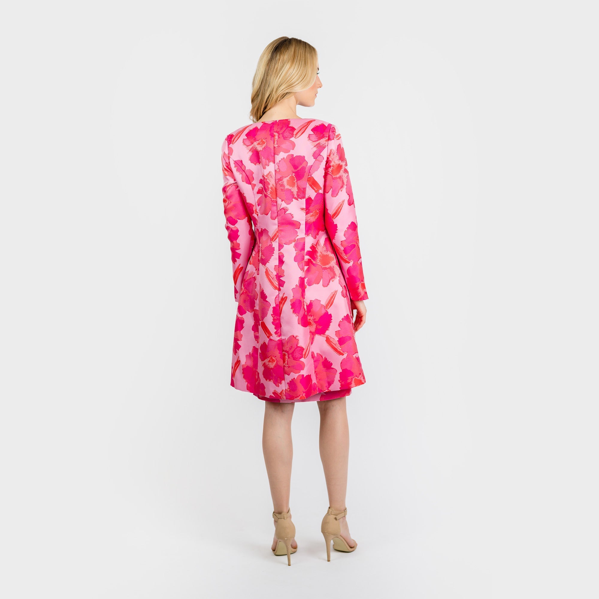Woman wearing a pink floral dress on a white background