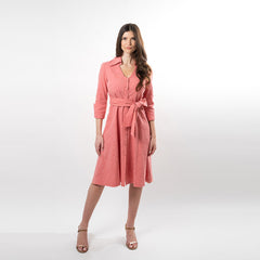 Woman wearing a pink dress with a belt on a white background