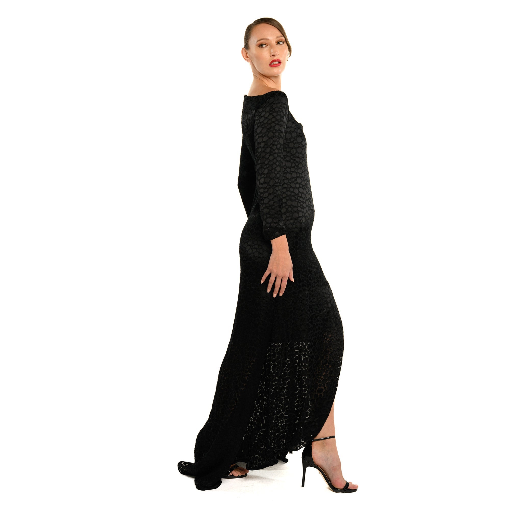 Woman wearing a black dress with a slit on a white background