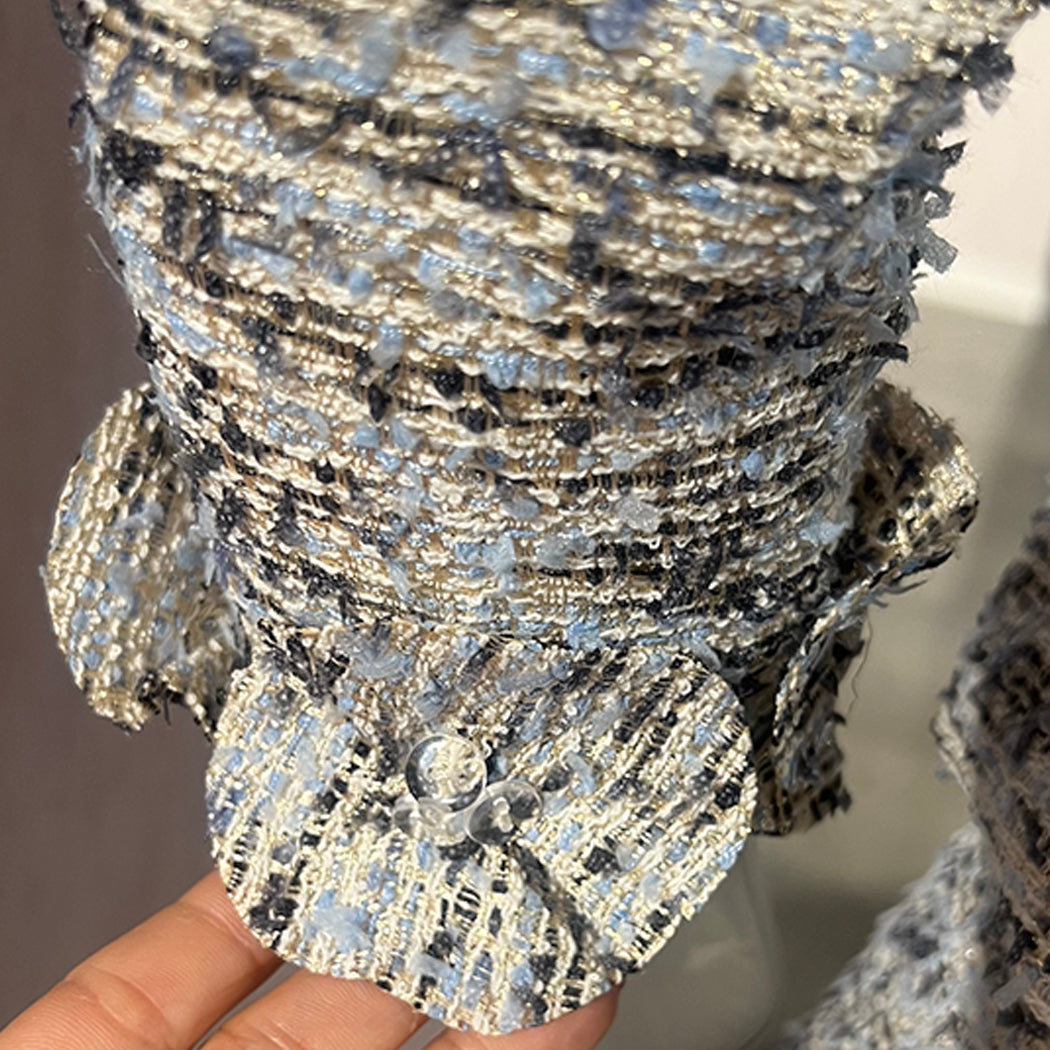 Close-up of a textured, silver and black decorative item held by a hand.