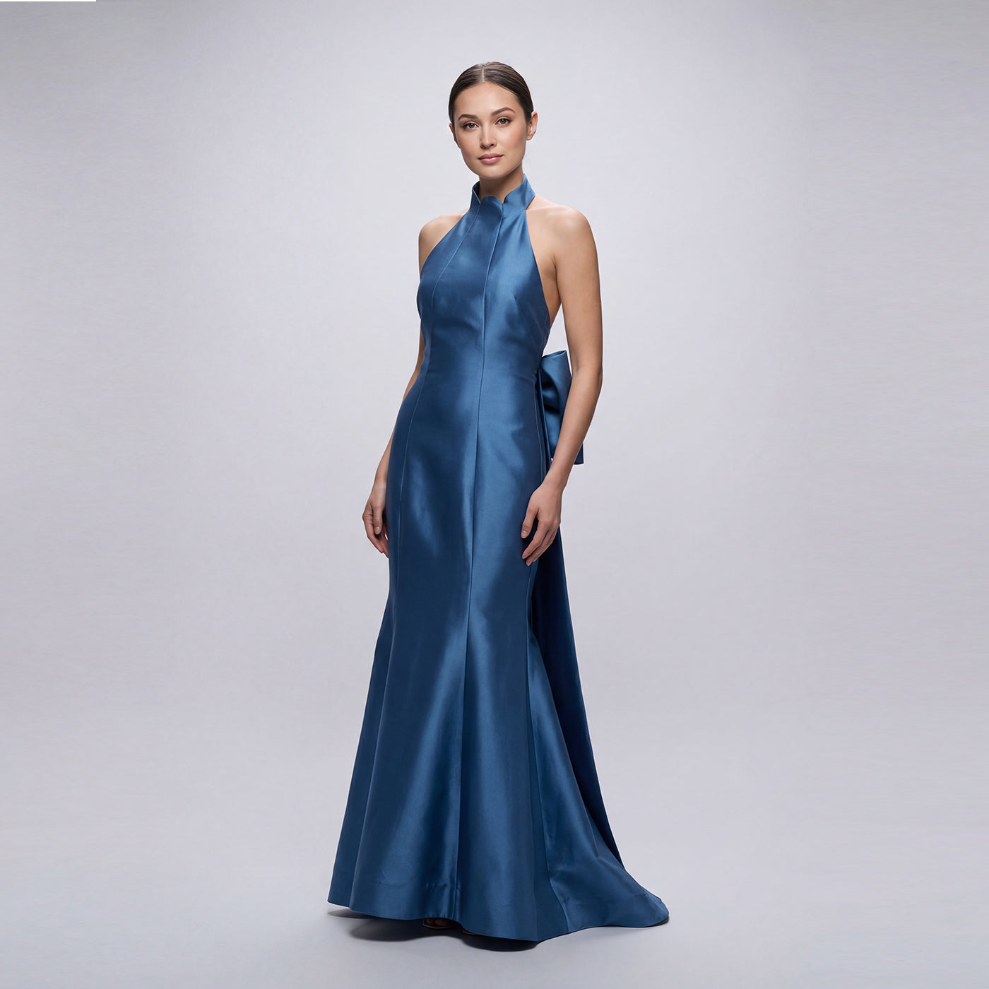 Woman wearing a blue evening gown on a plain background