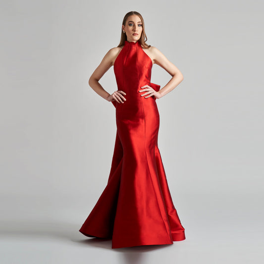 Woman wearing a red evening gown on a gray background