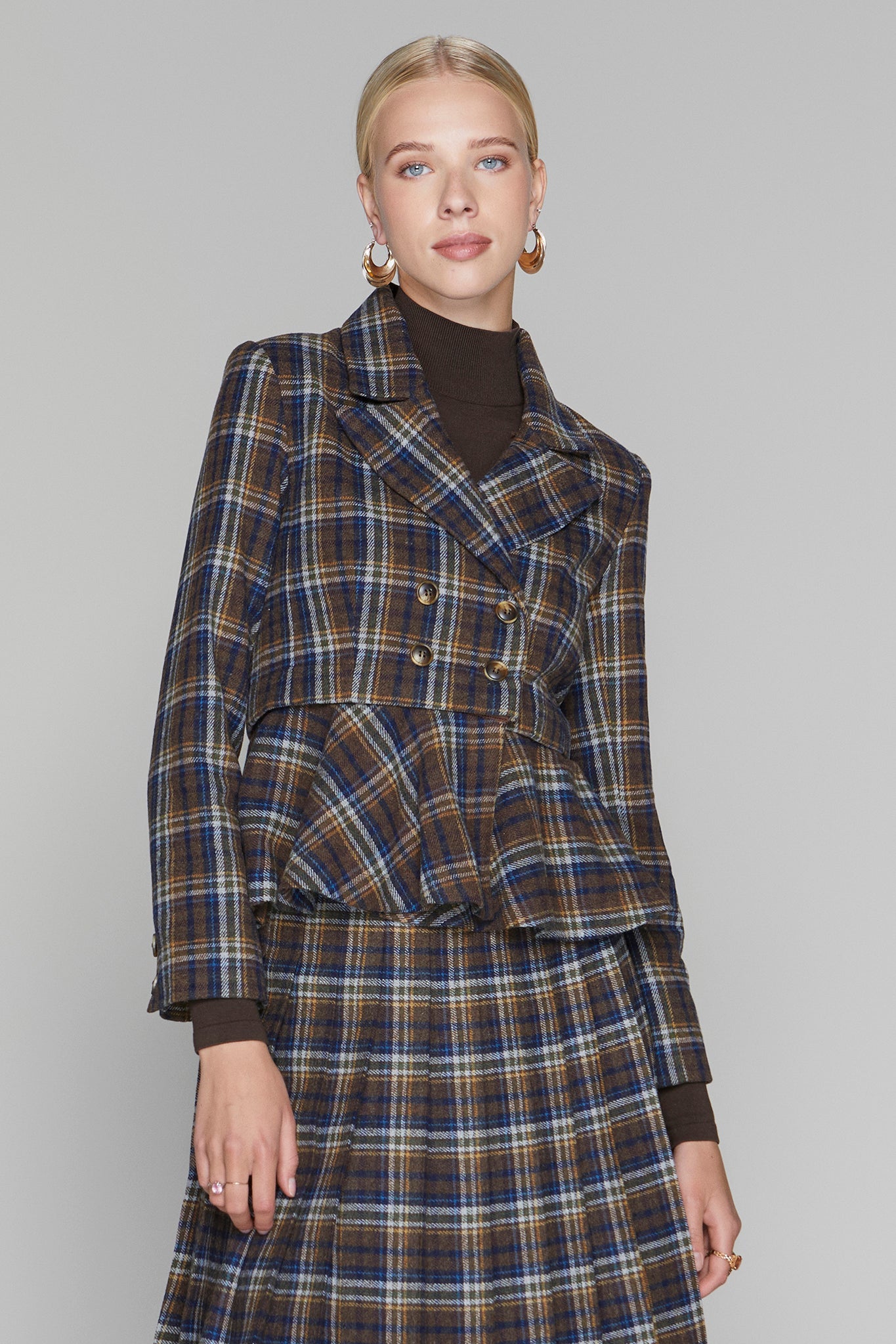 Woman wearing a plaid suit with a plain background